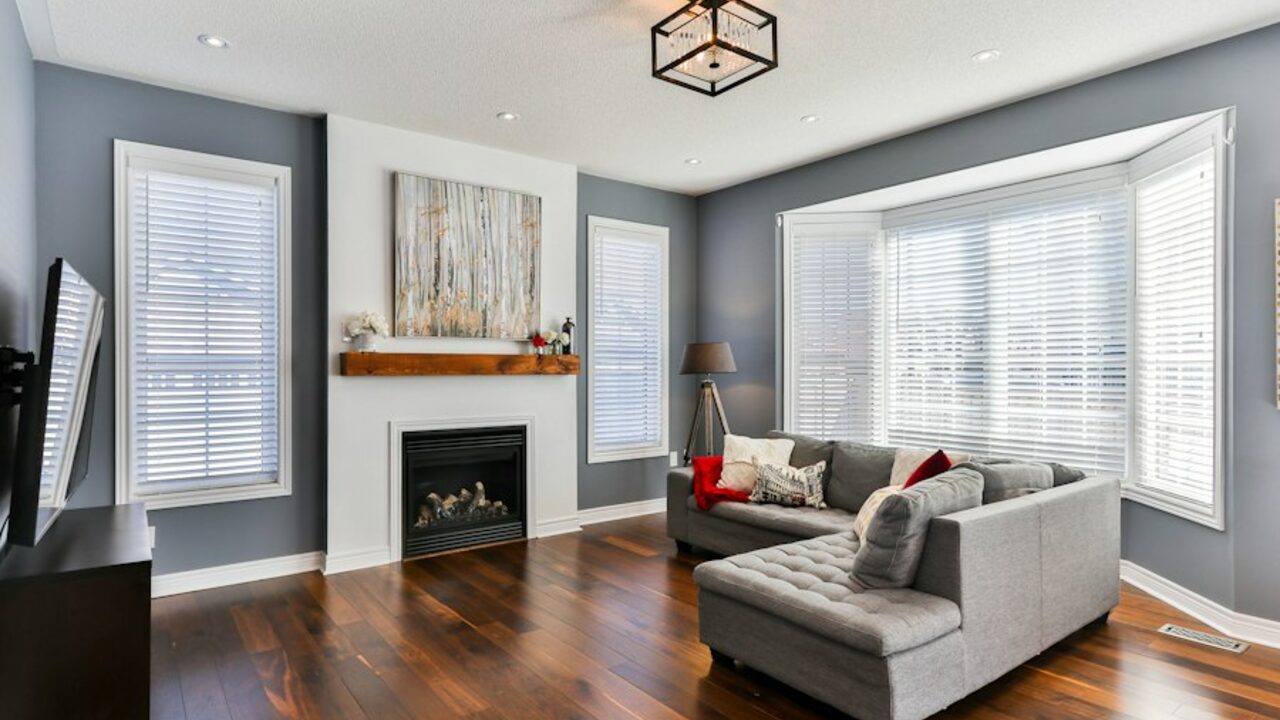 Concept visual: a premium living room with a fireplace, wide window and layered seating.