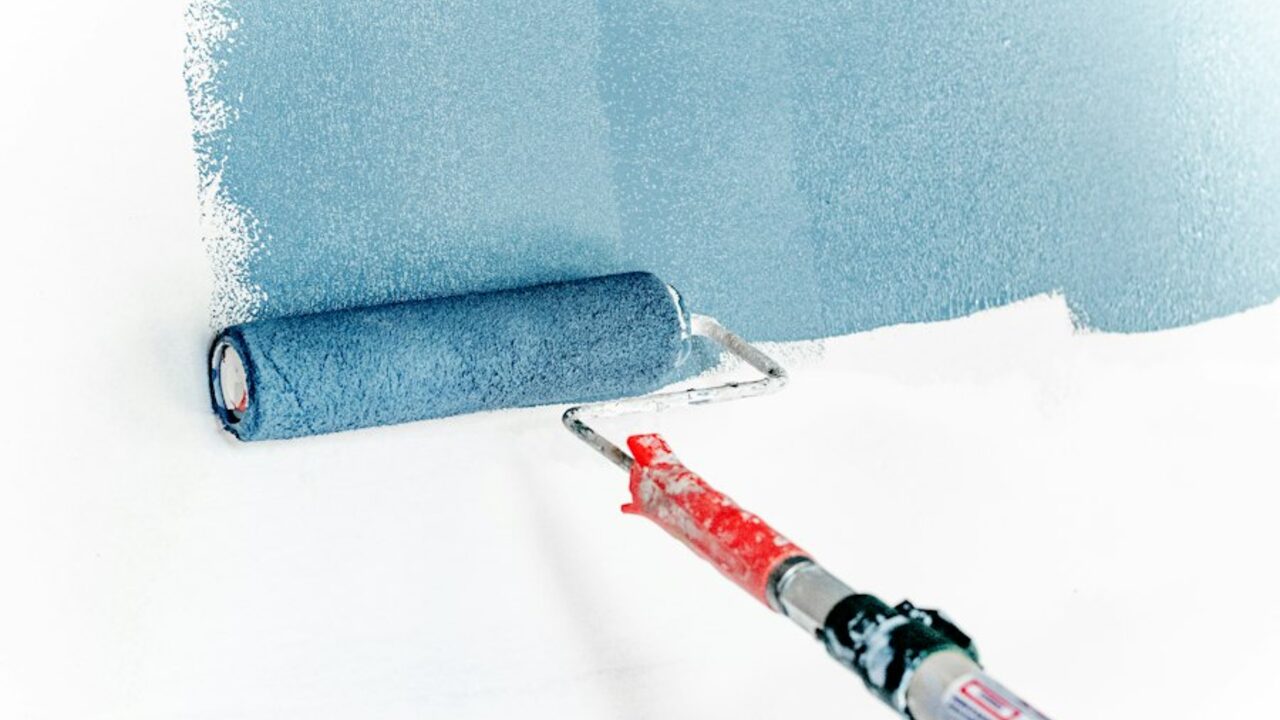 Paint roller applying a fresh coat of paint to a prepared wall.